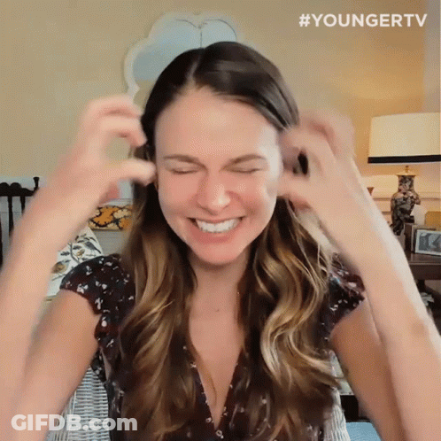 Woman Smiling And Covering Ears In Younger TV Shirt GIF