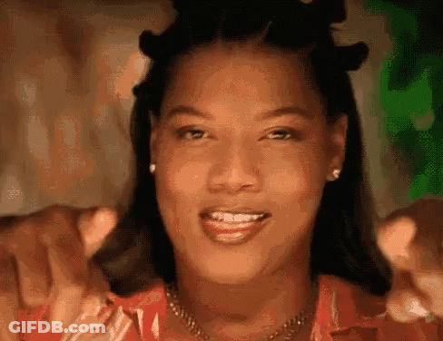 Woman Smiling And Pointing At Camera With Necklace And Earrings GIF
