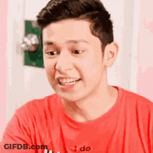 Woman Smiling And Waving On Couch GIF
