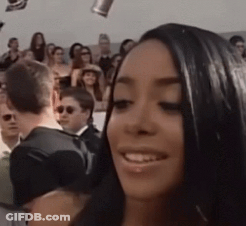 Woman Smiling At Microphone In Front Of Crowd GIF
