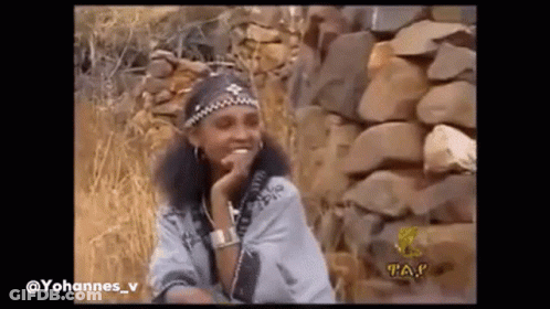 Woman Smiling Beside Stone Wall GIF