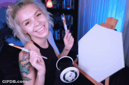 Woman Smiling Holding Brush And Canvas On Easel GIF
