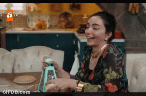 Woman Smiling Holding Grater In Kitchen GIF