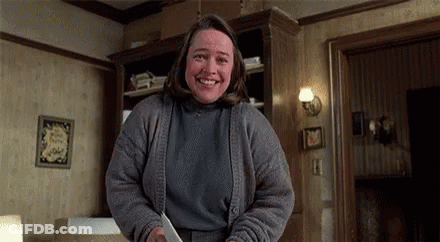 Woman Smiling Holding Knife In Living Room GIF
