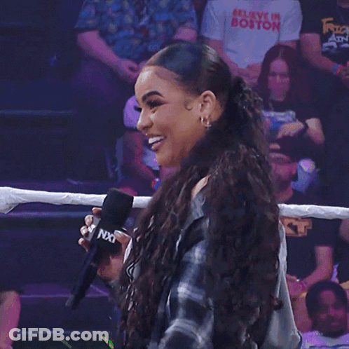 Woman Smiling Holding Microphone At W Sign GIF