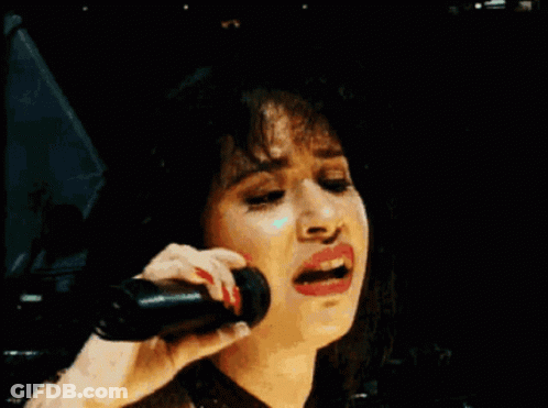 Woman Smiling Holding Microphone To Ear GIF