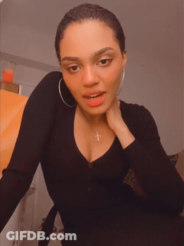 Woman Smiling In Black Shirt With Cross Necklace GIF