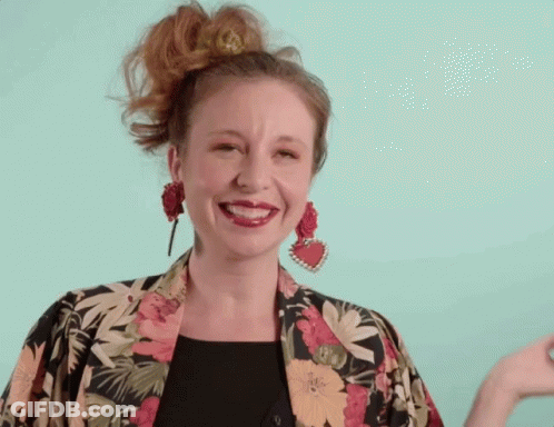 Woman Smiling In Floral Jacket And Earrings GIF