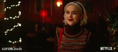 Woman Smiling In Front Of Christmas Tree And Netflix Logo GIF