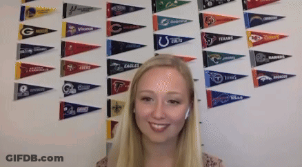 Woman Smiling In Front Of Eagles Pennants GIF