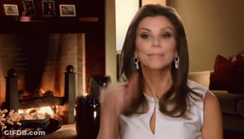 Woman Smiling In Front Of Fireplace GIF