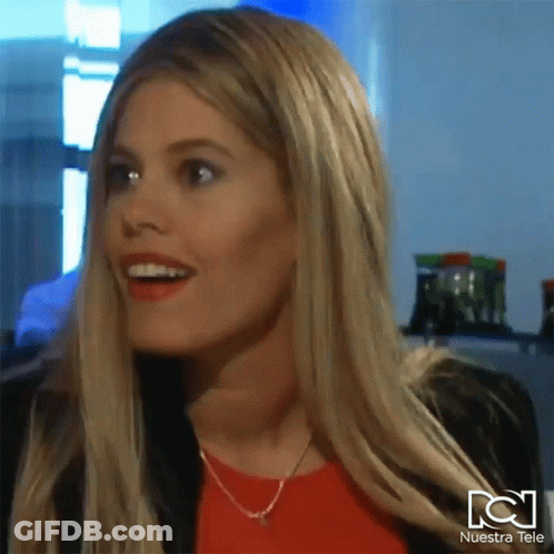 Woman Smiling In Front Of Nuestra Tele Sign GIF