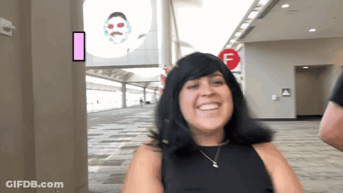 Woman Smiling In Front Of Red F Sign GIF