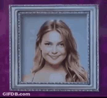 Woman Smiling In Picture Frame On Purple Wall GIF