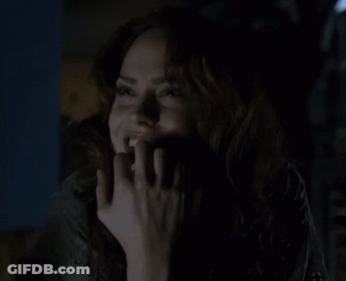 Woman Smiling In The Dark With Hand On Face GIF