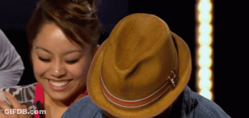 Woman Smiling Next To Man With Hat GIF