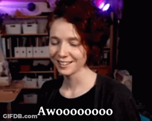 Woman Smiling With Eyes Closed In Room With Shelf GIF