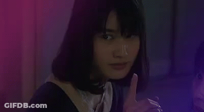 Woman Smoking Cigarette Covering Mouth In Dark Room GIF