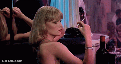 Woman Smoking Cigarette In Front Of Mirror GIF