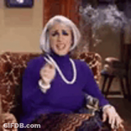 Woman Smoking Cigarette In Purple Sweater And Necklace GIF