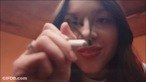 Woman Smoking Cigarette With Marker On Nose GIF