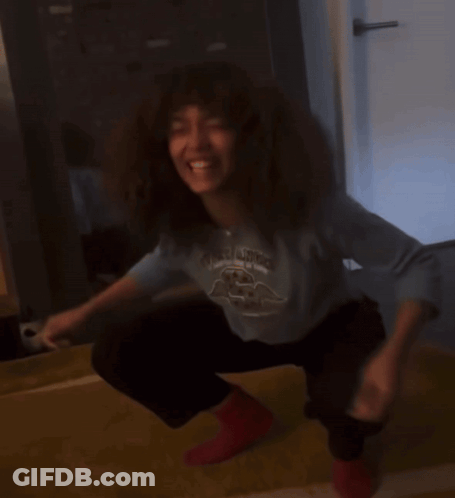 Woman Squatting In Blue Shirt With Bird And Red Socks GIF