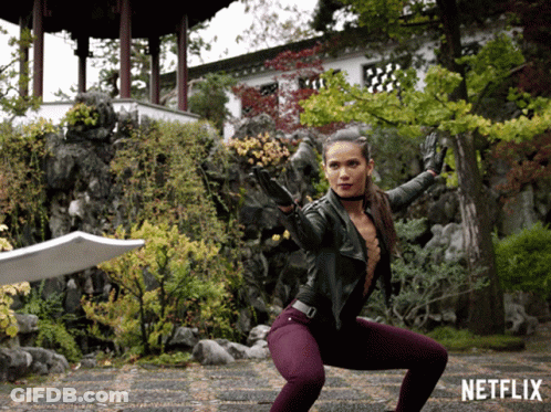 Woman Squatting With Sword In Front Of Netflix Sign GIF