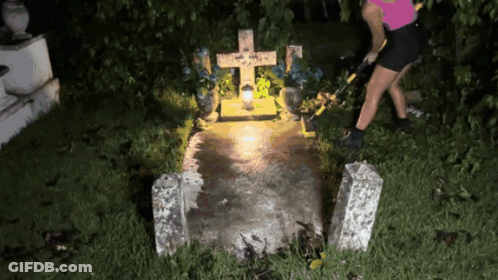 Woman Standing At Grave With Cross And Candle GIF