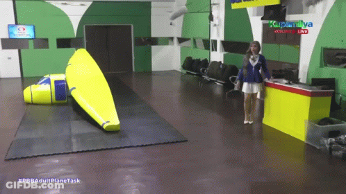 Woman Standing At Yellow Table #Pbbadultplane Task GIF