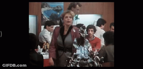 Woman Standing Before Dragon Statue In Crowded Room GIF