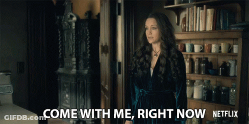 Woman Standing By Bookshelf Saying Come With Me GIF