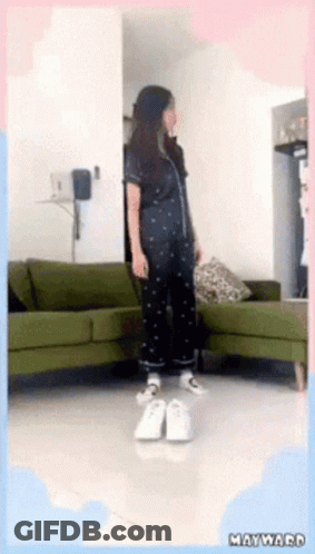 Woman Standing By Green Couch In Living Room GIF