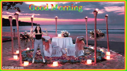 Woman Standing By Table And Chairs Saying Good Morning GIF