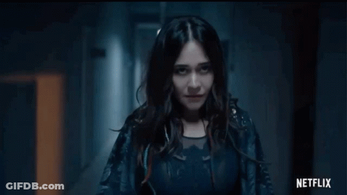 Woman Standing In Dark Hallway With Netflix Logo GIF