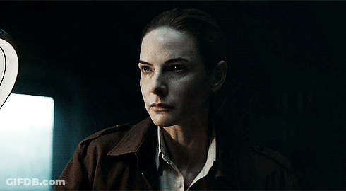 Woman Standing In Dark Room With Light Behind Her GIF