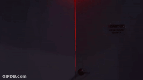 Woman Standing In Dark Room With Red Light GIF