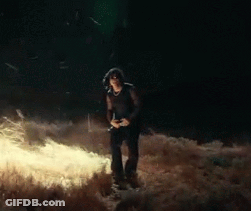 Woman Standing In Field At Night With Camera GIF