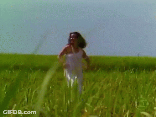 Woman Standing In Field Of Tall Grass GIF