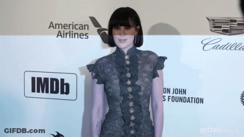 Woman Standing In Front Of American Airlines And IMDb Wall GIF