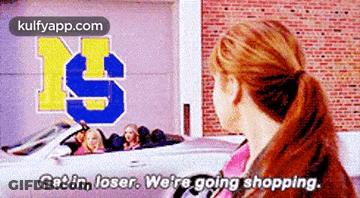 Woman Standing In Front Of Car Saying Get In Loser We're Going Shopping GIF