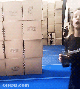 Woman Standing In Front Of Cardboard Boxes Saying T & P GIF
