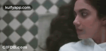 Woman Standing In Front Of Checkered Wall GIF