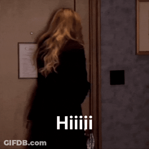Woman Standing In Front Of Door With Hiiiiii GIF