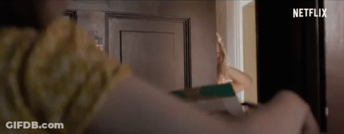 Woman Standing In Front Of Door With Netflix Logo GIF
