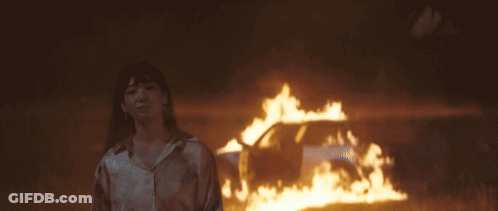 Woman Standing In Front Of Fire GIF