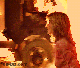 Woman Standing In Front Of Fire And Tire GIF
