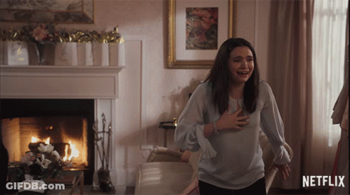Woman Standing In Front Of Fireplace And Netflix Logo GIF