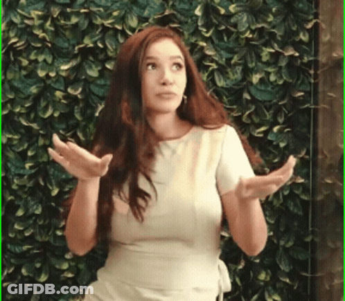 Woman Standing In Front Of Green Wall With Hands Out GIF