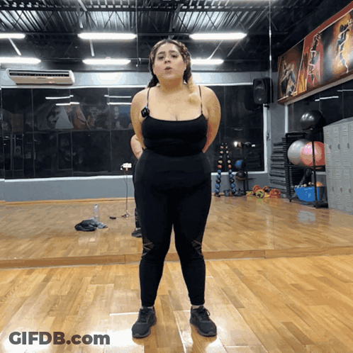 Woman Standing In Front Of Gym Mirror GIF