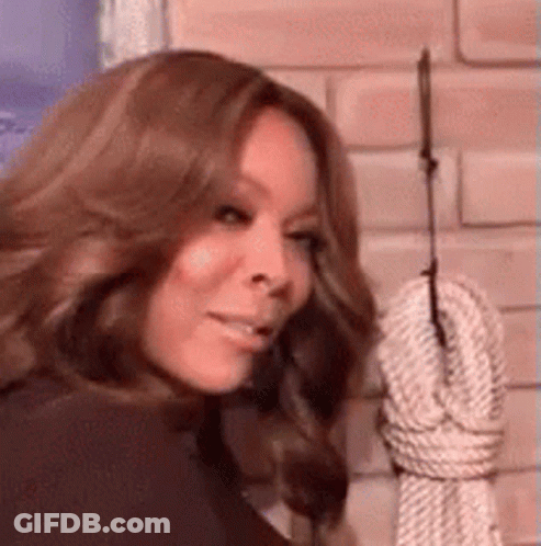 Woman Standing In Front Of Hanging Rope On Brick Wall GIF